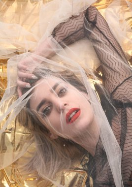 Altın folyoda, tül kumaşın altında güzel bir kız..