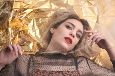 Altın folyoda, tül kumaşın altında güzel bir kız..