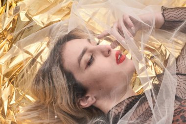 Altın folyoda, tül kumaşın altında güzel bir kız..