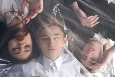 Tül kumaşın altında üç güzel genç insanın portresi..