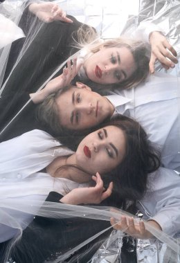 Tül kumaşın altında üç güzel genç insanın portresi..