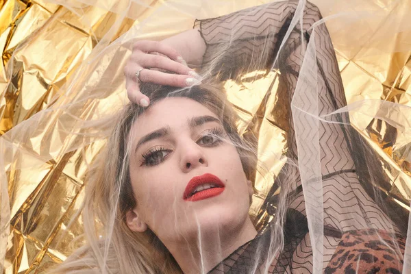 Altın folyoda, tül kumaşın altında güzel bir kız..