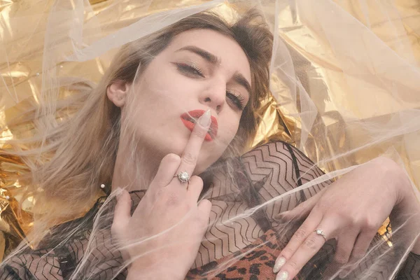 Altın folyoda, tül kumaşın altında güzel bir kız..