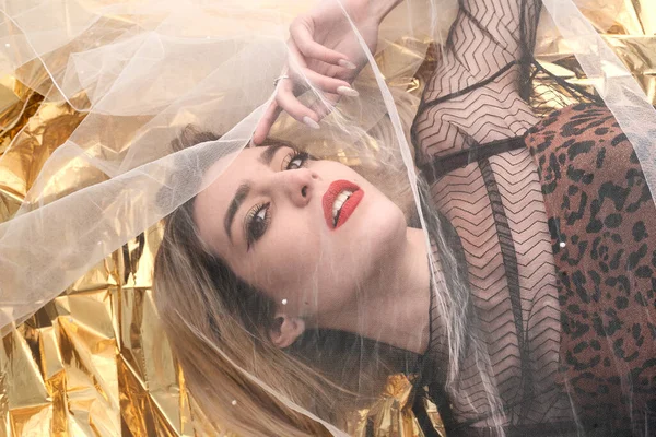 Altın folyoda, tül kumaşın altında güzel bir kız..