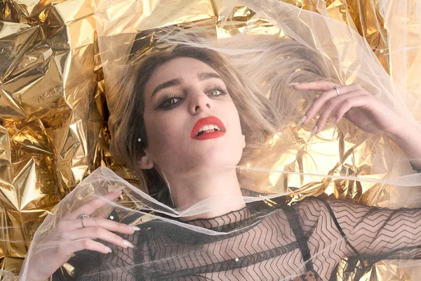 Altın folyoda, tül kumaşın altında güzel bir kız..