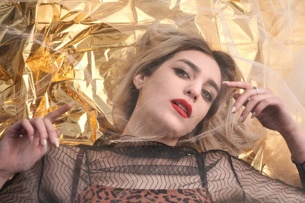 Altın folyoda, tül kumaşın altında güzel bir kız..