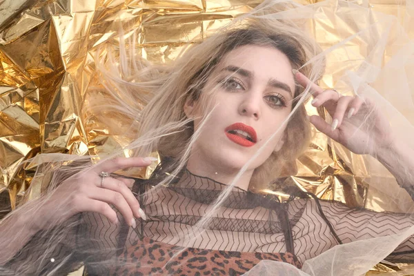 Altın folyoda, tül kumaşın altında güzel bir kız..