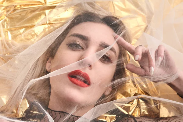 Altın folyoda, tül kumaşın altında güzel bir kız..