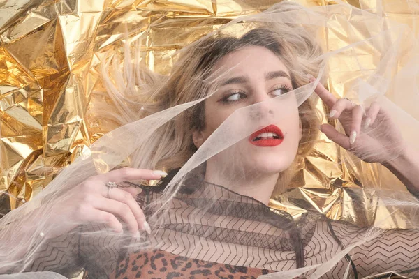 Altın folyoda, tül kumaşın altında güzel bir kız..