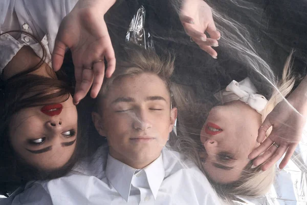 Tül kumaşın altında üç güzel genç insanın portresi..