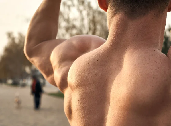 Güneşli bir günde gezinti güvertesinde poz veren kaslı fitness modeli.