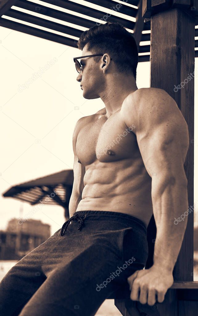 Handsome, muscular, male fitness model posing outdoor.