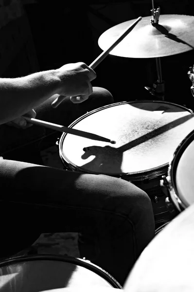 Drummer beats drums with drumsticks, close-up photo.