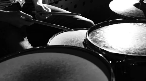 Drummer beats drums with drumsticks, close-up photo.