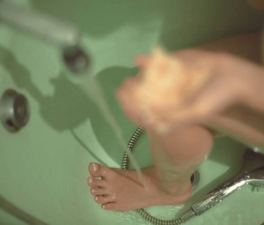 Banyoda kadın ayağı var. Kız banyo yapıyor. Fotoğraf bulanık..