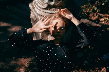 Doğanın ve eski mimarinin arka planında benekli elbiseli bir kızın şık portresi..