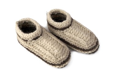 Beyaz arka planda izole edilmiş koyun postu yününden sıcak örülmüş çoraplar. Büyük örgü. Eski iklimler, geleneksel yün çoraplar. Kahverengi bej rengi, şekli.