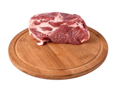 Beyaz arka planda tamamen çiğ domuz eti var. Tahta bir tahtanın üzerinde basit bir et kompozisyonu. Yan görünüm ve tahtadaki boşluk.