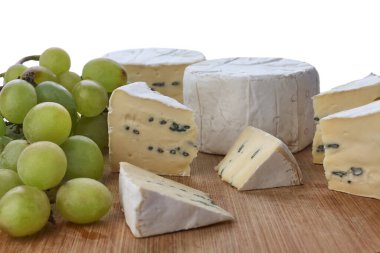 Beyaz arka planda izole edilmiş tahtadan yapılmış peynir ve üzümlerle dolu bir hayat. Yan görünüm.