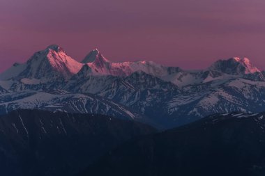 Huso dağ güzel karlı zirveleri karşı günbatımı pembe gökyüzüne zemin üzerinde güneşin son ışınları
