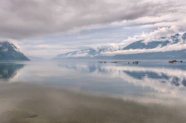 Şaşırtıcı kabarık bulutlar, dağlar, sis ve thunderclouds arka planı Gölü su onların yansımaları