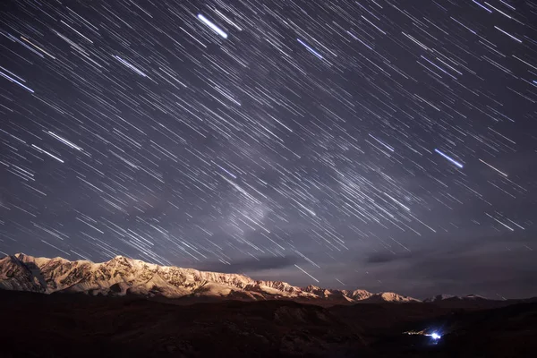 バックライト付き月と雪山の背景に星空のトラックの形で星のカラフルなトラック — ストック写真