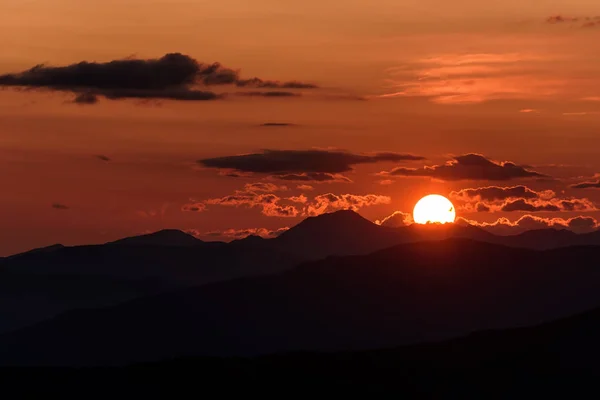 太陽と雲の日の出山の輪郭の円板とカラフルな風景 — ストック写真
