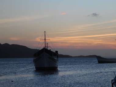 geri gün batımı ile sakin suda portre tekne