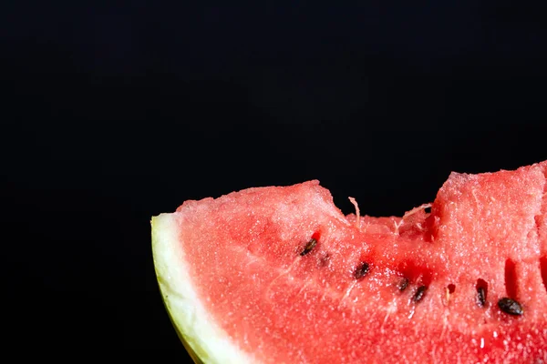Bit slice of watermelon on black background