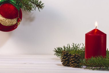 Çam kozalağı ve köknar ağacı ile kırmızı yanan mum, metin için kopya alanı ile kış dekorasyon kartı