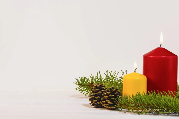 Beyaz arka planda iki yanan mumlar ile Noel dekorasyon, metin için kopya alanı ile kış tatili kartı