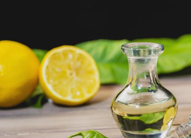Siyah arka plan ile cam şişe limon uçucu yağ, alan görüntü kopyalamak