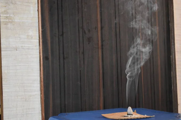 Tütsü çubuğu dumanlı bir masa. Seçici odaklanma. Siyah bir arkaplanda.