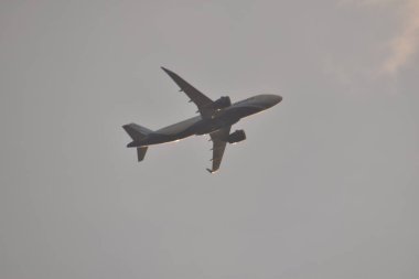 Hindistan 'da gün batımında bulutların arasından yükselen bir hava düzlüğü..