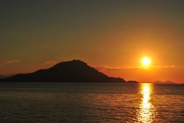 Sahilde tropikal gün batımı. Labuan Bajo, Fores, Endonezya