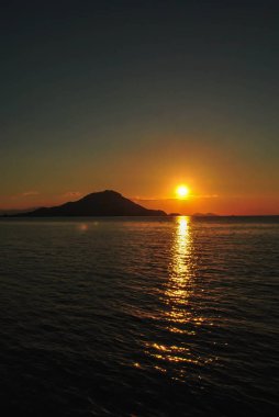 Tropikal Komodo adasında sakin deniz üzerinde gökyüzü ile güzel gün batımı, Labuan Bajo, Fores, Endonezya