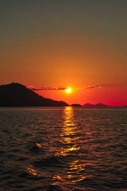 Turuncu gökyüzü ve deniz dalgaları arka plan ile Amazing gün batımı. Tropik Komodo adasında Güzel Gün Batımı, Labuan Bajo, Fores, Endonezya