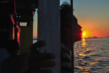 çok güzel bir gün batımında dudakları ile güneş öpüşme. Tropik Komodo adasında Güzel Gün Batımı, Labuan Bajo, Fores, Endonezya