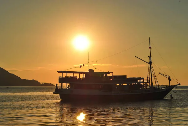 Barco à vela no mar ao pôr-do-sol. Belo pôr do sol na ilha tropical de Komodo, Labuan Bajo, Fores, Indonésia — Fotografia de Stock