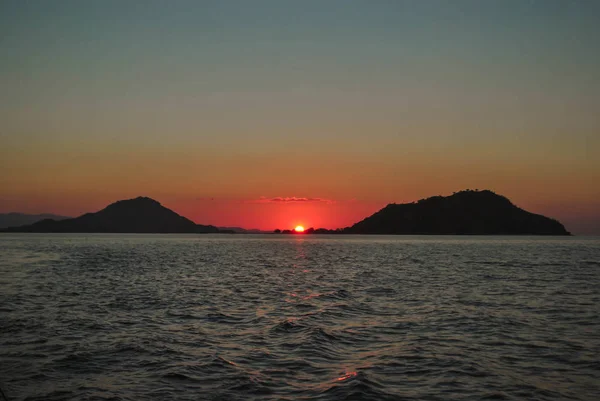 Belo pôr do sol no fundo da noite luz do sol mar. Belo pôr do sol na ilha tropical de Komodo, Labuan Bajo, Fores, Indonésia — Fotografia de Stock