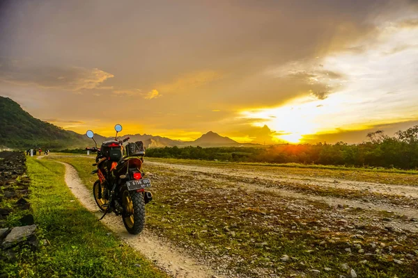 Purwakarta, West Java, Indonesia (03/30/2018) : Motorcycle on the side of the Jatiluhur Reservoir with a beautiful sunset