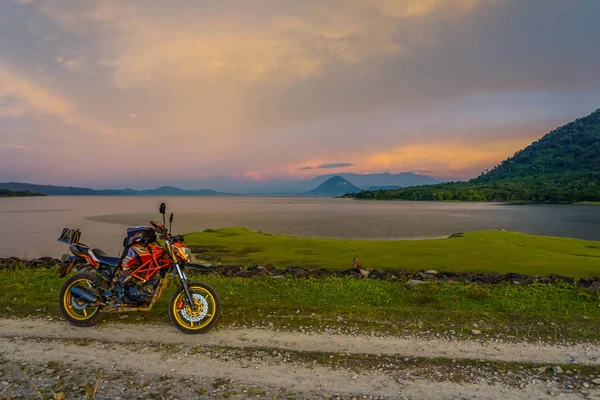 Purwakarta, West Java, Indonesia (03/30/2018) : Motorcycle on the side of the Jatiluhur Reservoir with a beautiful sunset