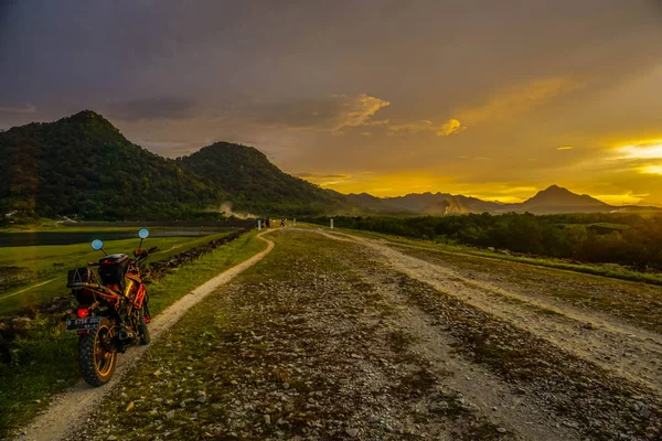 Purwakarta, West Java, Indonesia (03/30/2018) : Motorcycle on the side of the Jatiluhur Reservoir with a beautiful sunset