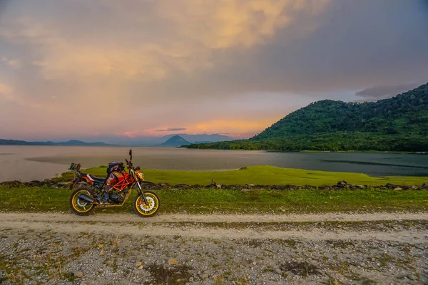 Purwakarta, West Java, Indonesia (03/30/2018) : Motorcycle on the side of the Jatiluhur Reservoir with a beautiful sunset