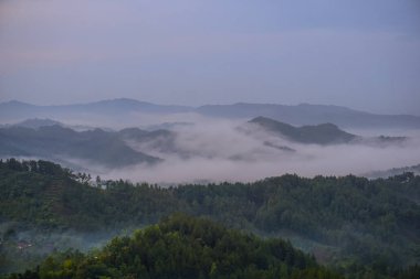 Güneşin doğuşu ve tepelerin üzerindeki renkli gökyüzü. Buluh Payung Tepesi, Kebumen, Merkez Java, Endonezya