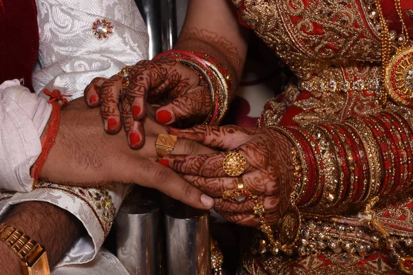 Indian couple Ring ceremony. Indian ritual seen before wedding hand shake together bride with groom. Indian loving couple is getting married. lovely bride hands with mehndi.