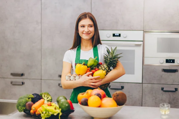 Uma menina sorrindo segurando frutas nutritivas e vegetais — Fotografia de Stock