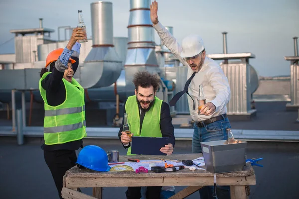 Tre lavoratori godono guardando un video divertente, dopo una dura giornata di lavoro — Foto Stock