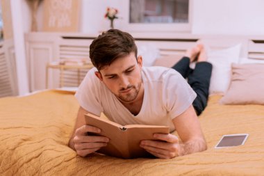 Sabah ciddi adam yatakta, rahat bir atmosfer üzerinde bir kitap okuma kişisel bir zaman var