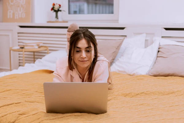 Chica feliz navegar por Internet en un ordenador portátil en el dormitorio en casa —  Fotos de Stock